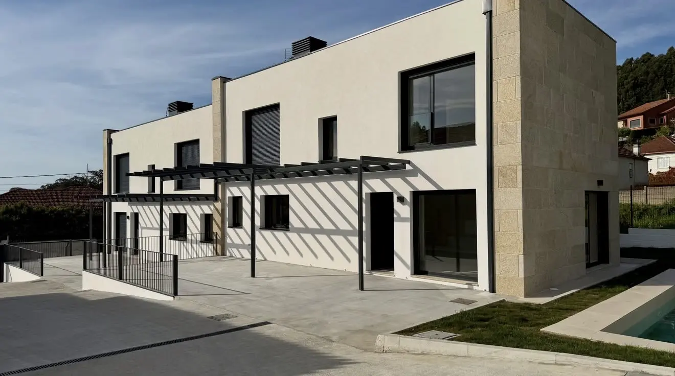 El frente de las cuatro viviendas de Castrelos terminado, con las pérgolas de acero sobre las terrazas