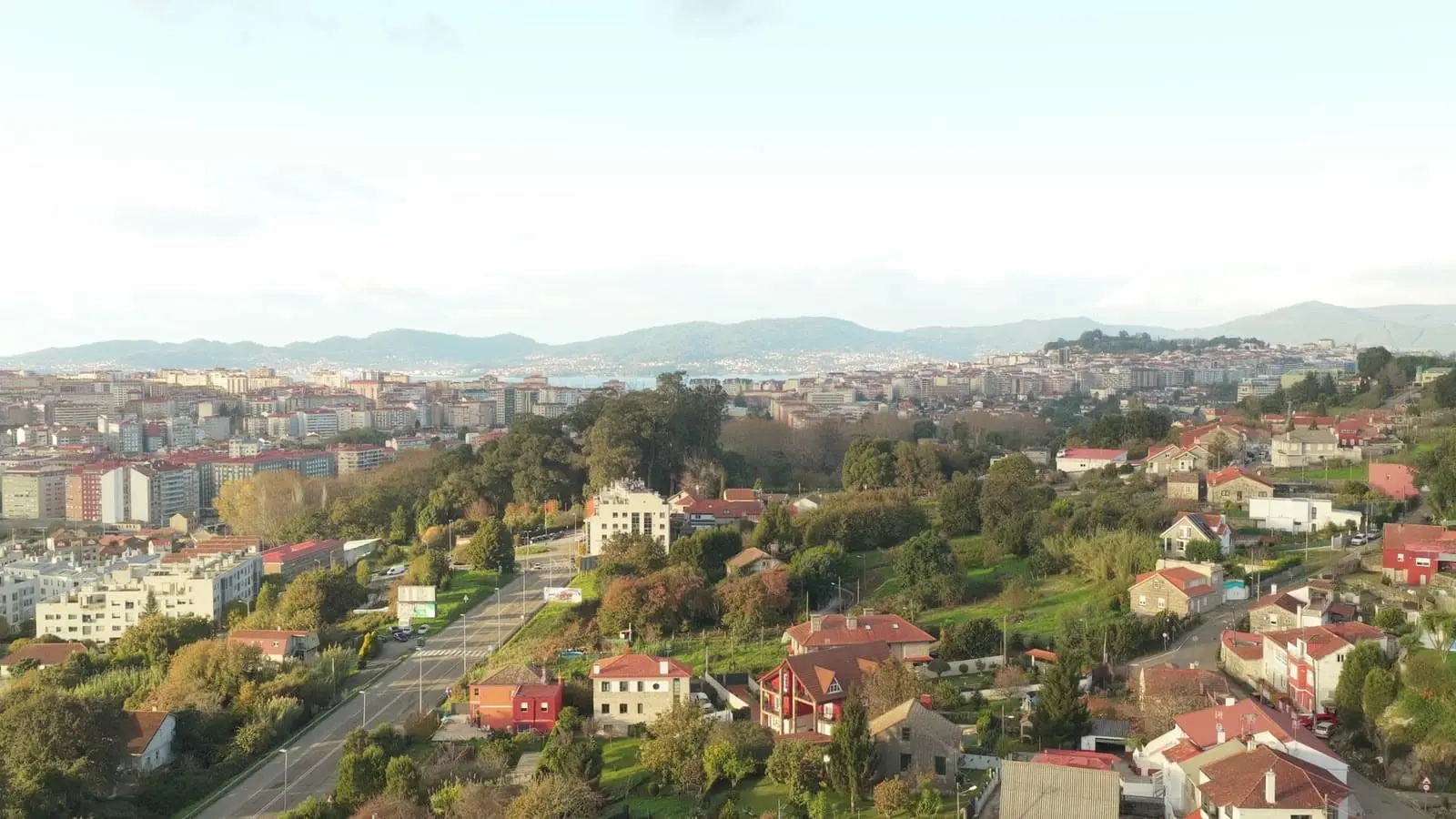 Panorámica de dron desde la obra de Castrelos sobre los tejados de Vigo, con la ría al fondo